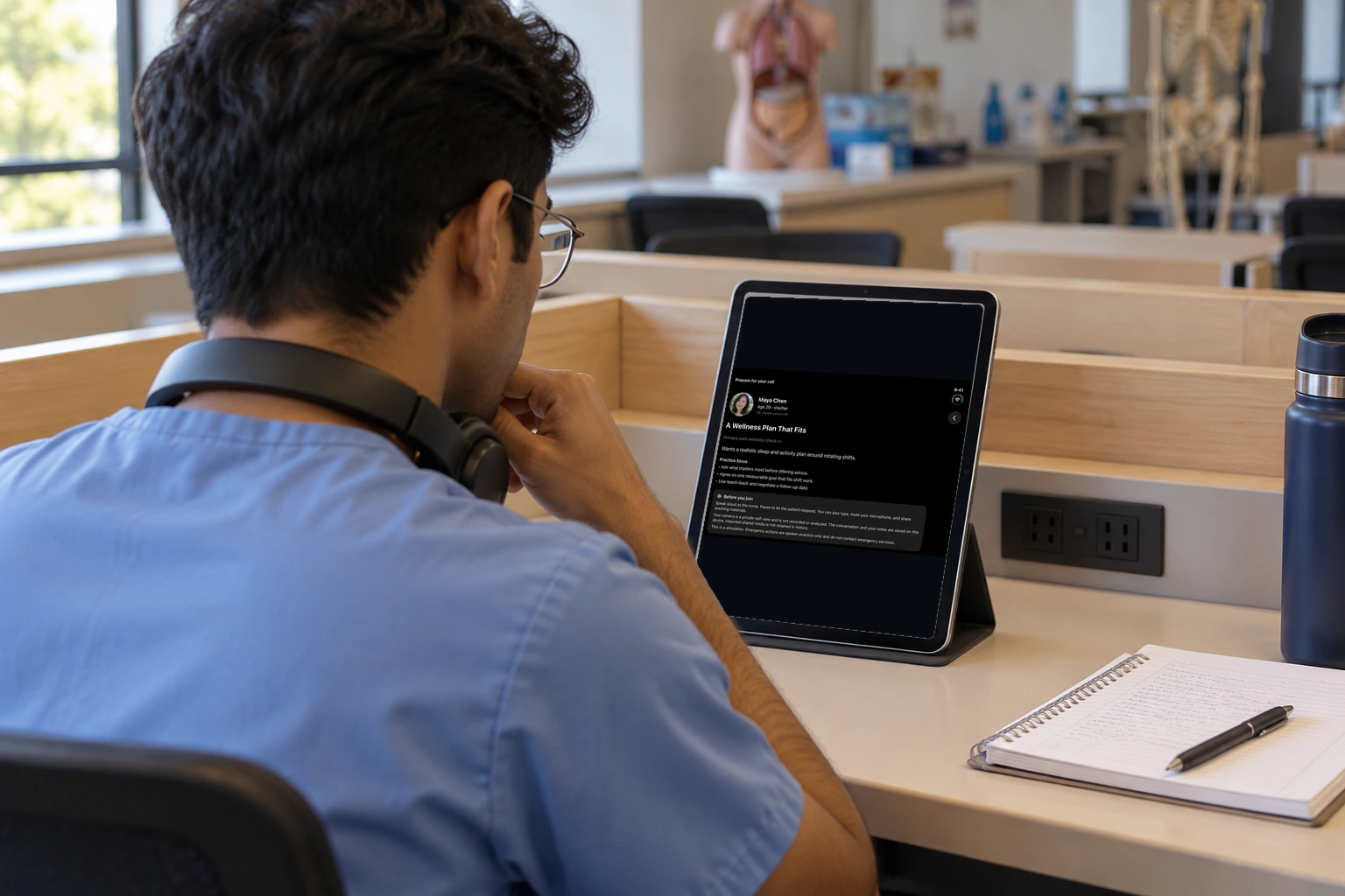 A student with headphones reviews an iPad. The screen shows the fictional patient's concern and a communication challenge that can be left on.