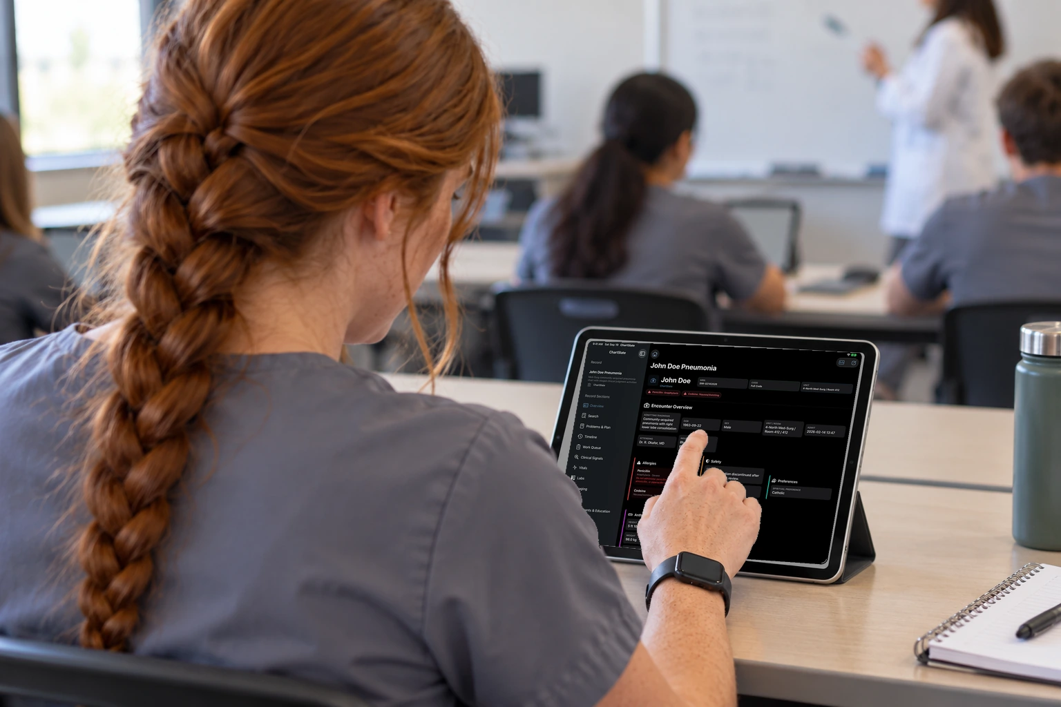 Two students share an iPad open to a simulated chart overview.